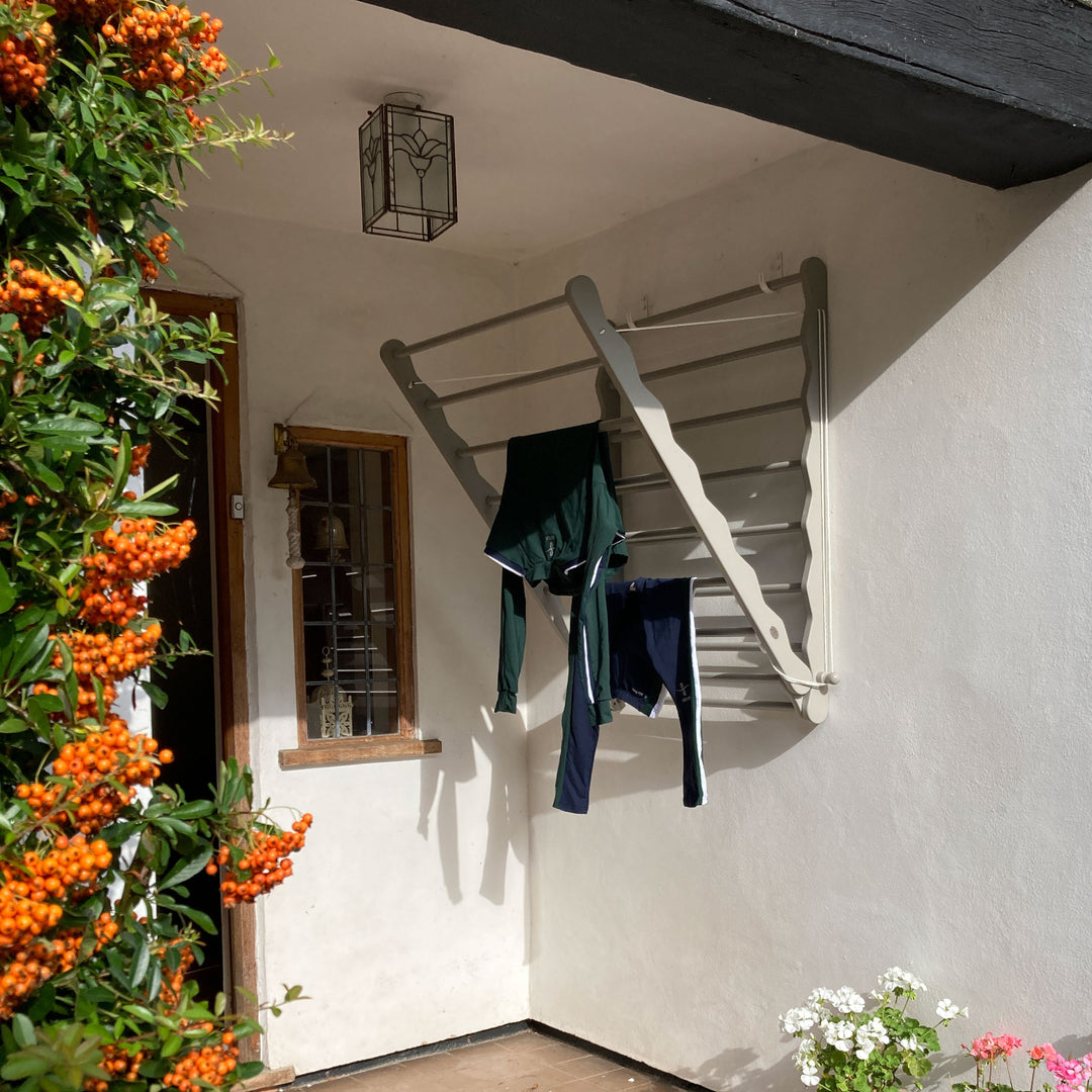 Image of Julu Doris wall mounted clothes airer in grey, being used outside