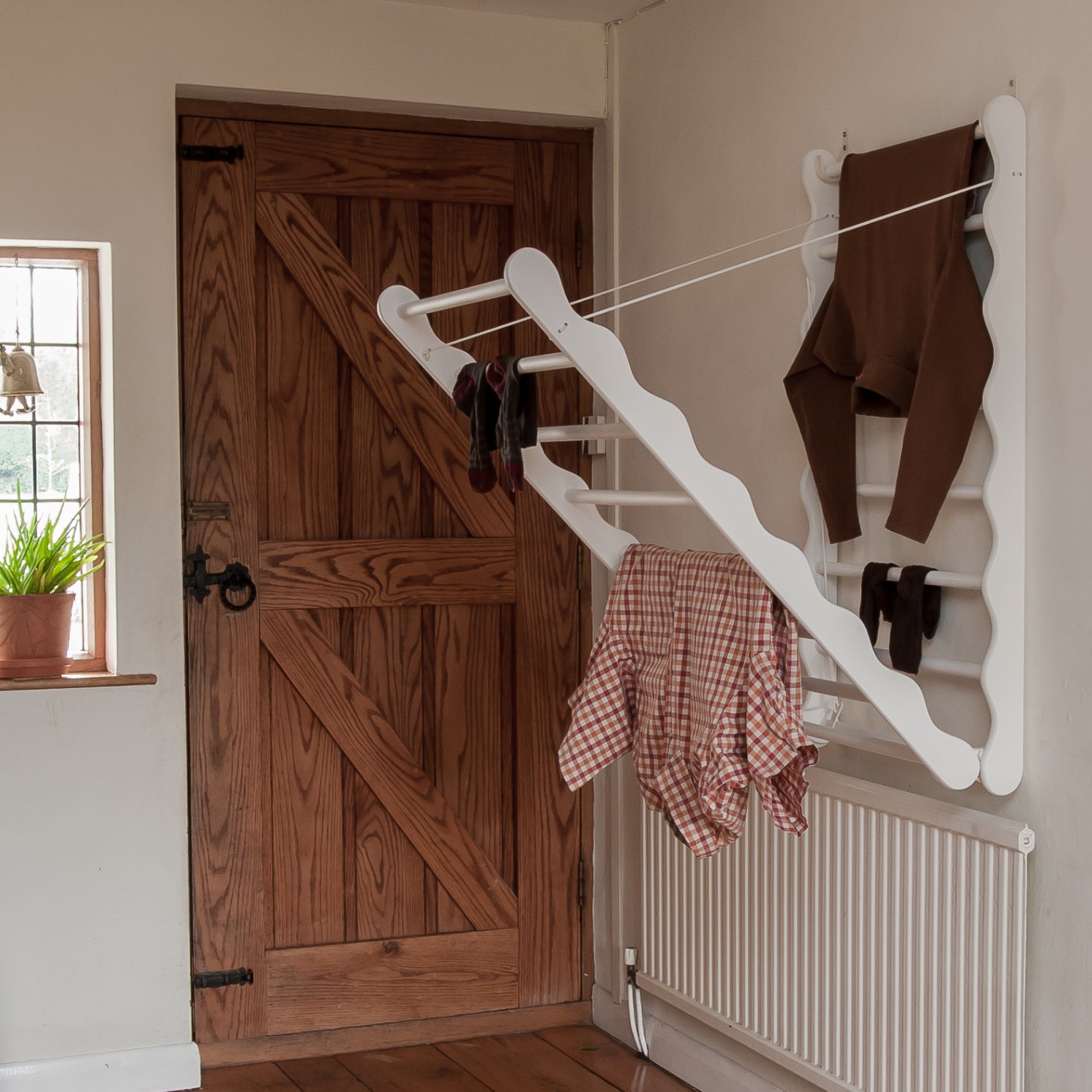 Slightly open wooden clothes drying rack. Designed and made by Julu
