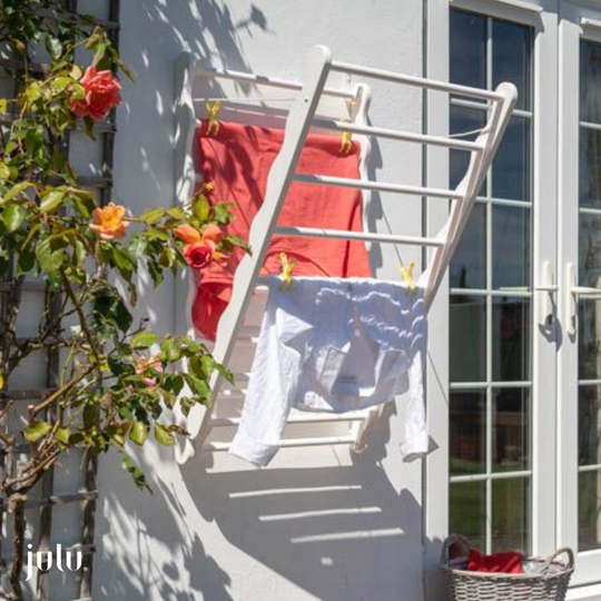 Image shows wall mounted clothes airer hanging on an outside wall by Julu