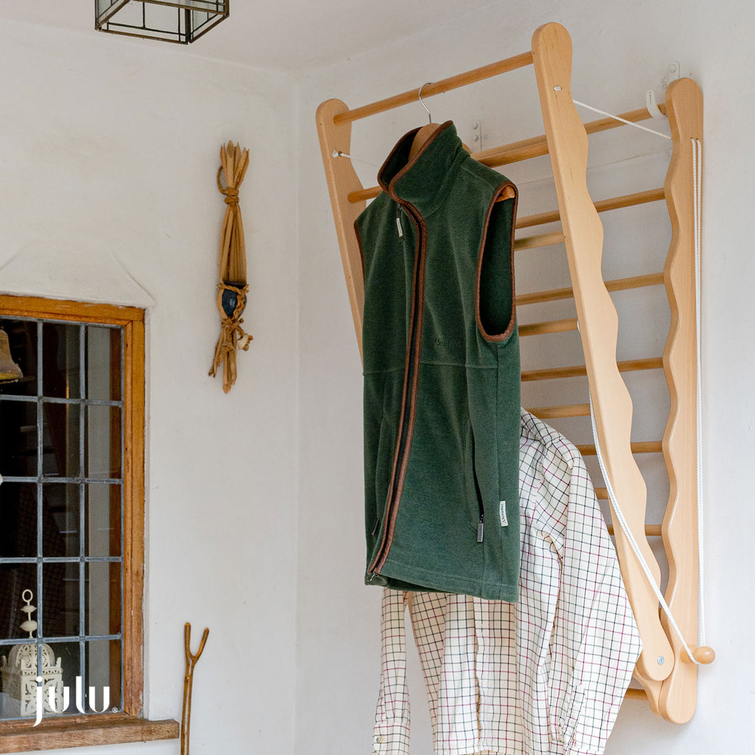 Image of wall mounted clothes dryer rack hanging in a porch by Julu